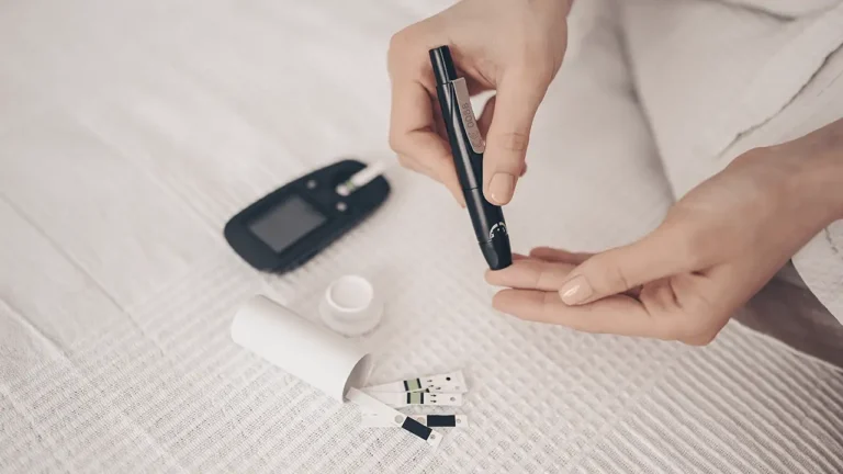 Pessoa usando um sensor de glicose no braço e uma bomba de insulina, compondo o sistema de pâncreas artificial híbrido.