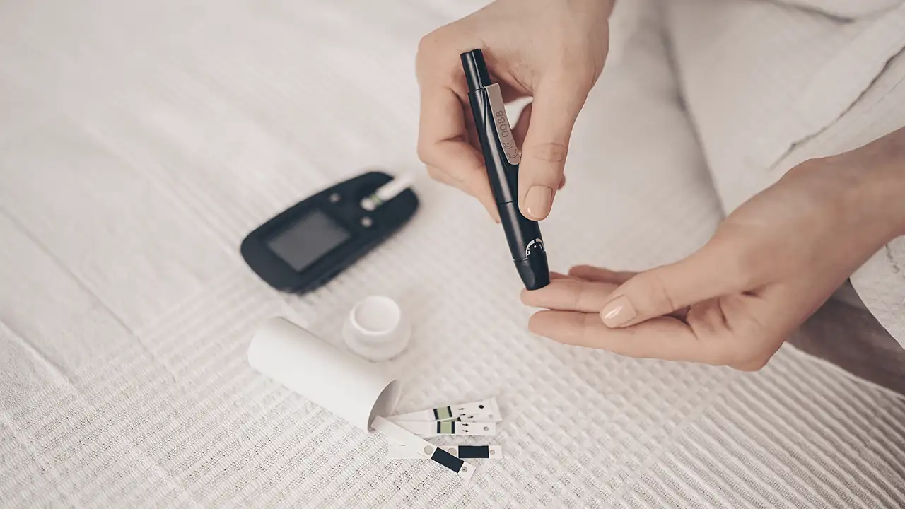 Pessoa usando um sensor de glicose no braço e uma bomba de insulina, compondo o sistema de pâncreas artificial híbrido.