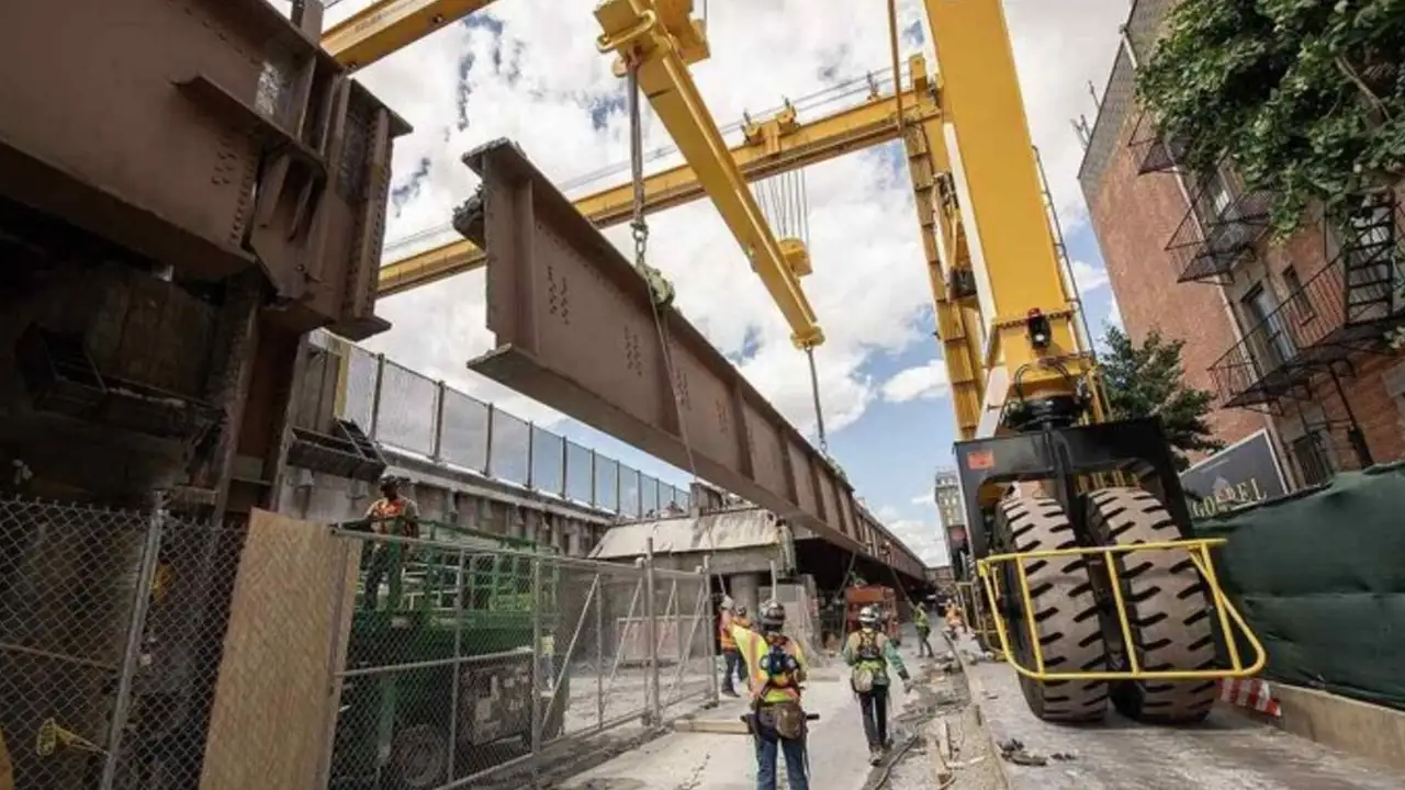 Uma foto da nova ponte sendo deslizada para o lugar ou uma imagem dividida ("Antiga" vs "Nova") com guindastes e operários trabalhando nos trilhos.